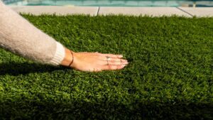 a woman's hand feeling the soft density of artificial grass