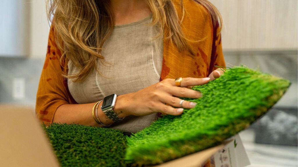 closeup of a woman testing out different artificial grass samples