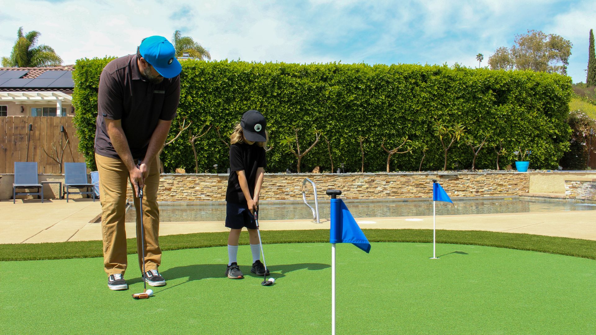 a photo of a father and son practicing their putting on a backyard putting green