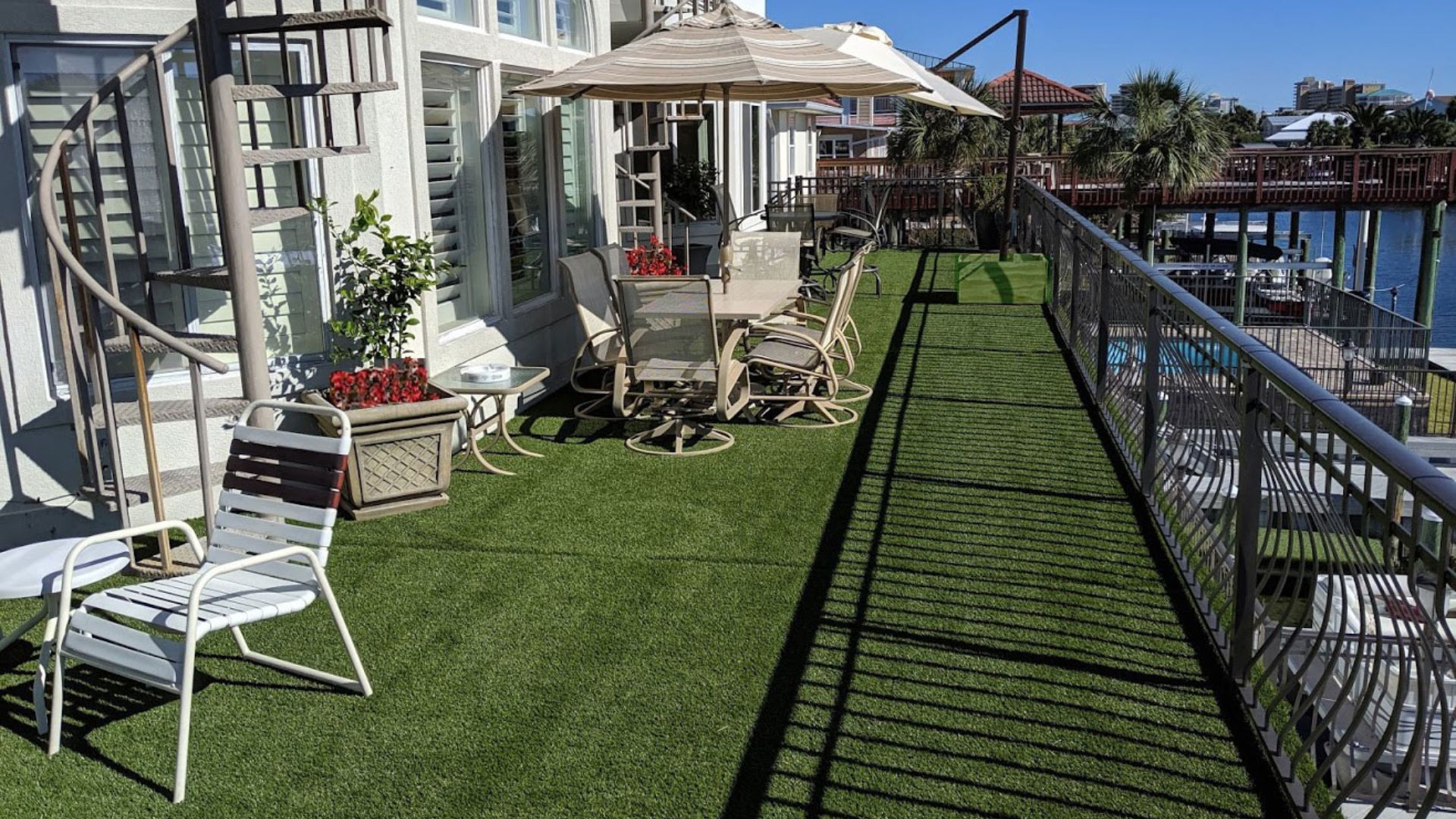 a photo of residential 50t artificial grass on a waterside deck o na sunny day